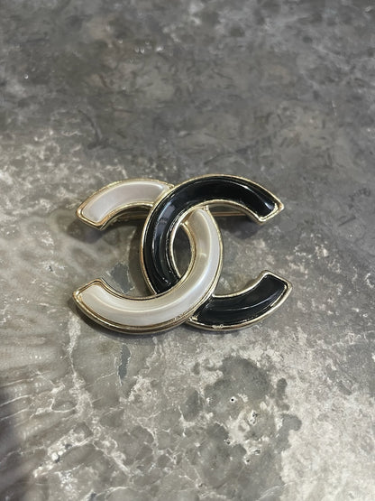 Broche Chanel CC noire et blanche